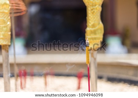 Close up of Incense sticks burning with white smoke on incense pot in the temple.