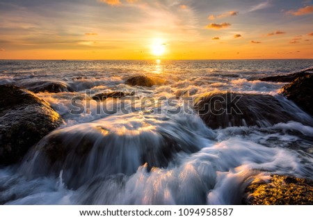 Seascape awesome wave on the rock with coloful sunset at beach in phuket thailand