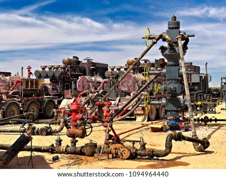 Fracking, well head connected to fracking pumps. Royalty-Free Stock Photo #1094964440