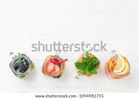 Fresh lemonade jar with summer fruits and berries. Top view with space for your text