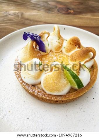 Lemon Meringue Tart with white plate on the table


