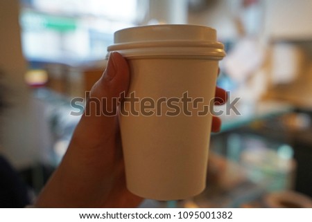 Close up Hand holding hot coffee in white take away cup