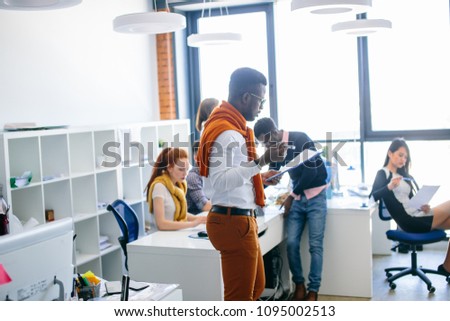 young energetic office worker in casual outfit reading important paper at workplace