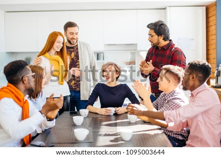 employees enjoying spending time togeter while drinking coffee in office kitchen Royalty-Free Stock Photo #1095003644
