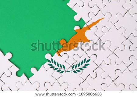 Cyprus flag  is depicted on a completed jigsaw puzzle with free green copy space on the left side.