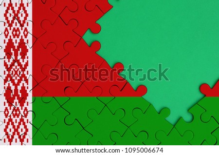 Belarus flag  is depicted on a completed jigsaw puzzle with free green copy space on the right side.