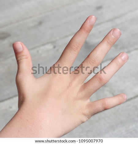 Children's palm with splayed fingers on the background of gray boards