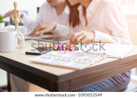 Asia Graphic designer working on computer tablet and Coloring device in studio office.