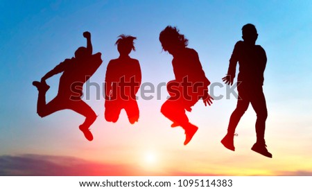 Silhouette Happy men jumping In beautiful sunset
