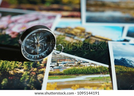 Compass on colorful autumn photograph of popular tourist destination background, China traveling concept