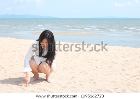 Asian teenage girl living on the sand are happy on the beach in a summer vacation.