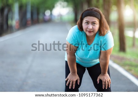 Exercise and healthy concept : Fat woman feeling tired while running in the park Royalty-Free Stock Photo #1095177362
