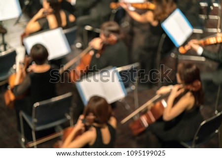 Blurred Artists symphony orchestra. Musician plays a musical instrument on the concert stage.