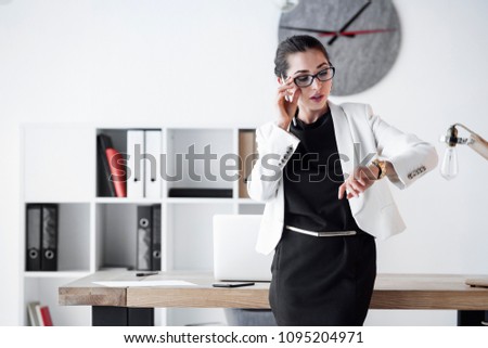 A female manager checking her wristwatch. Communicate about, time, business, deadlines, prompt deliveries, quick customer service, easy solutions, time saving.