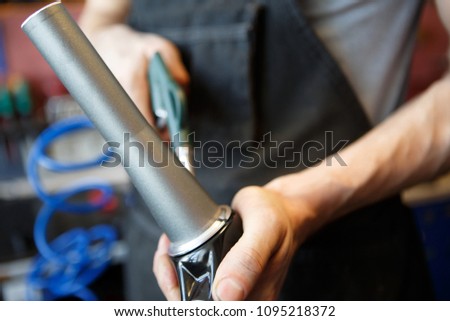 Image of master mending pipe in workshop