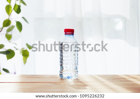 plastic water bottle on the wooden table, sunny day Royalty-Free Stock Photo #1095226232