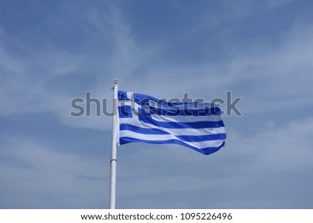 Photo of blue stripe Greek waving flag in slightly cloudy sky                 