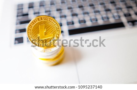 Litecoin and pile of coins on laptop computer, cryptocurrency concept