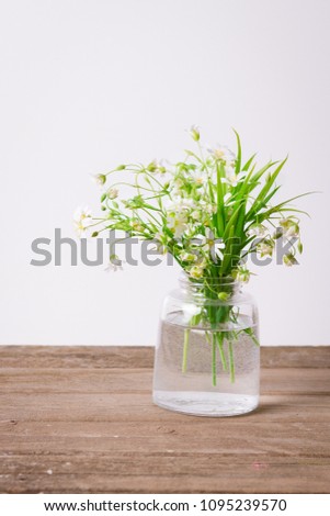 Bouquet of wild flowers in vase, on bright background