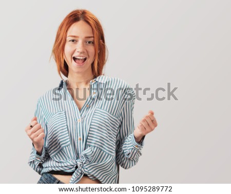 portrait of a pretty redhead girl celebrating something