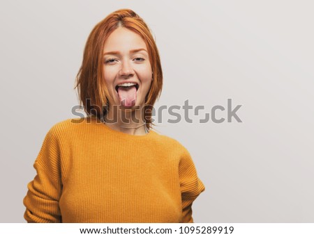 portrait of a pretty redhead girl showing her tongue
