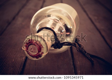 Ship in the bottle / Old sailboat sealed in a glass bottle on vintage wooden background
