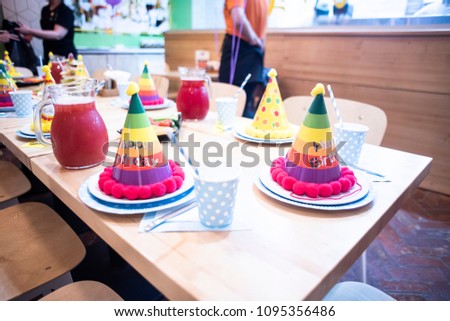 Kids birthday table decoration. Elegant table is ready for the children's holiday. The attributes and decorations child's birthday party. Caps and plates with cups. Happy birthday.