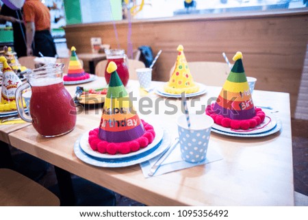 Kids birthday table decoration. Elegant table is ready for the children's holiday. The attributes and decorations child's birthday party. Caps and plates with cups. Happy birthday.
