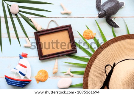 Summer Background,with picture frame,turtle,coconut leaves and hat on blue wood background.