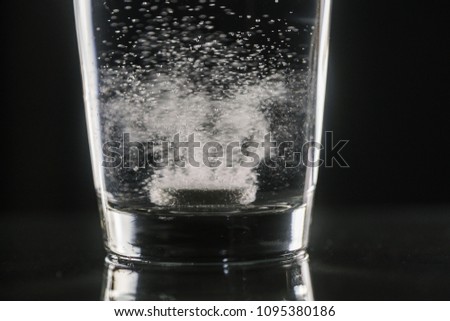 dissolving effervescent tablet in a glass of water