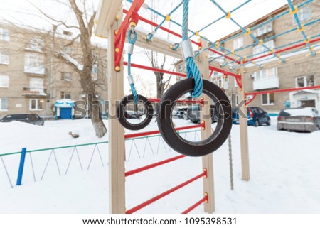 Multicolored children's playground in the courtyard in the winter