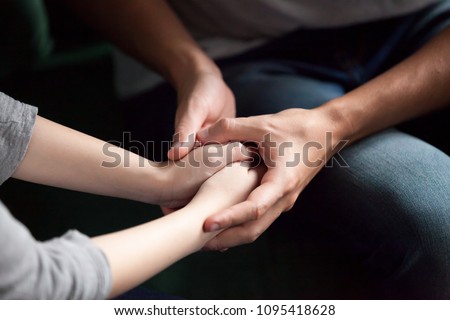 Close up view of couple holding hands, loving caring man supporting comforting woman, giving psychological support, help or protection, understanding in marriage relationships, reconciliation concept Royalty-Free Stock Photo #1095418628