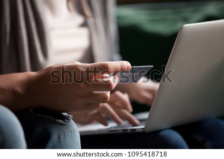 Paying money and buying online concept, couple doing internet shopping with computer, customers making secure payment on laptop via e-banking service, close up view of hand holding credit card Royalty-Free Stock Photo #1095418718