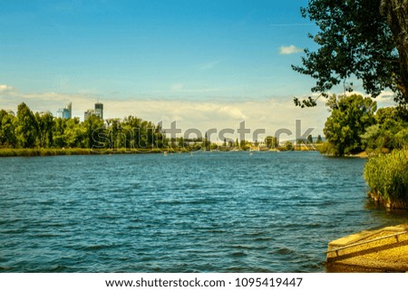 lake in summer with city skyline and people in the background