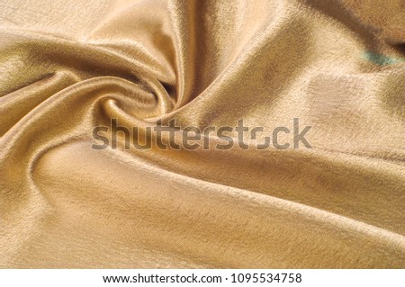 Fabric made of silk fabric metal thread metallic sheen gold.golden yellow Silk Charmeuse. Luminous and light-flowing steel metallic color