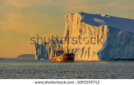 Greenland, Disko Bay. Tourists take pictures of the iceberg. Source of icebergs is by the Jakobshavn glacier. This is a consequence of the phenomenon of global warming and catastrophic thawing of ice
