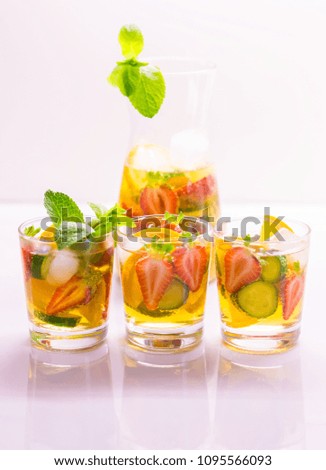 Delicious and tasty alcohol drink cocktail Pimms in the glasses. Drink background. Detox concept. Beautiful fruit salad with strawberries. Close up. Healthy diet.