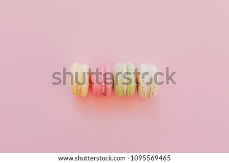 stylish colorful macaroons on trendy pink paper, flat lay. space for text. modern food photography concept. tasty pink, yellow, green, white  macarons, yummy background
