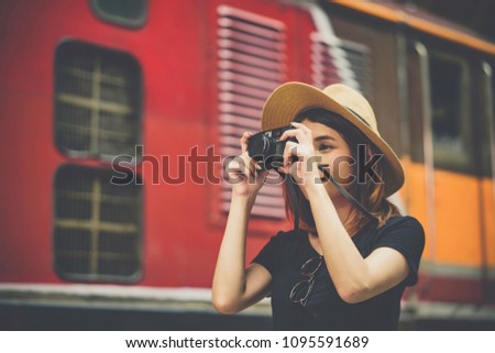 photographer woman girl is holding retro styled camera traveler at the train station, Travel lifestyle and seasonal vacation concept.