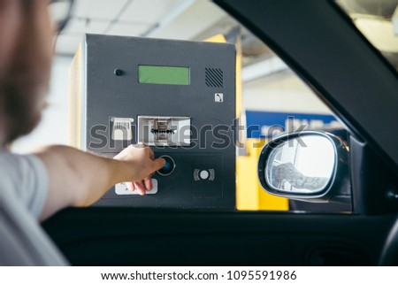 parking barrier. man taking ticket to pass control on parking area Royalty-Free Stock Photo #1095591986