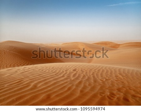 The dunes of the Wahiba Sands desert in Oman at sunset during a typical summer sand storm