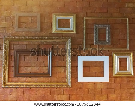 Small and large photo frame hanging on red brick