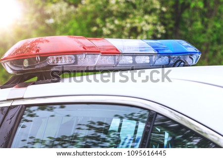 Police patrol car with sirens off during a traffic control. Blue and red flashing sirens of police car during the roadblock in the city. 
