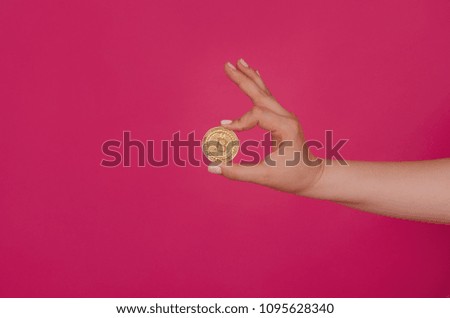 Cryptocurrency golden bitcoin coin on pink background. Hand holding symbol of crypto currency - electronic virtual money for web banking and international network payment
