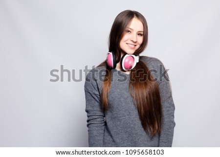 People, leisure and technology concept - happy woman or teenage girl in headphones listening to music from smartphone and dancing