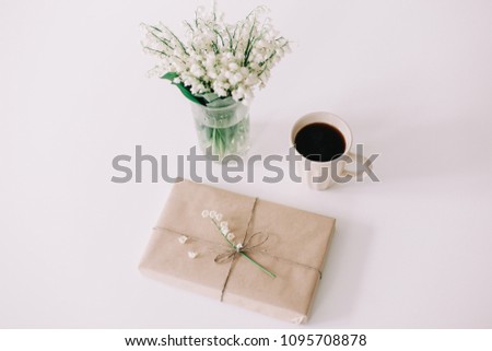 Romantic composition of a cup of coffee, book and flowers on white background. Flat lay, top view, spring concept
