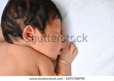 Newborn Concept. Newborn babies are sleeping in a bed. The baby is in the white bedroom.