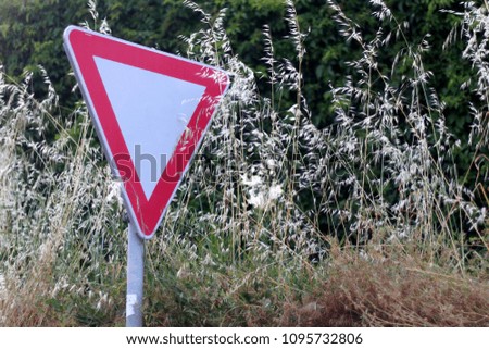 Traffic sign overgrown with weeds. Selective focus. 