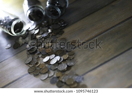 Accumulated coins stacked in glass jars on the floor
