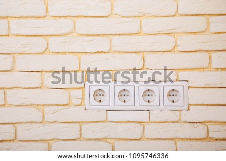 electrical outlets, four network sockets in the white brick wall, home electricity